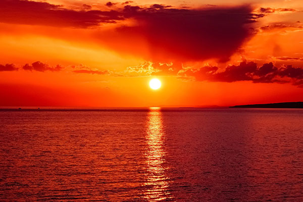 منظره غروب خورشید سرخ رنگ در دریا