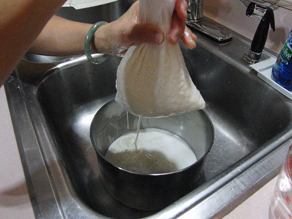 نحوه تهیه شیر سویا در خانه : شیر سویا را با استفاده از پارچه ی نخی صاف کنید